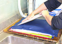 couching a sheet of handmade paper onto a post of sheets and felts